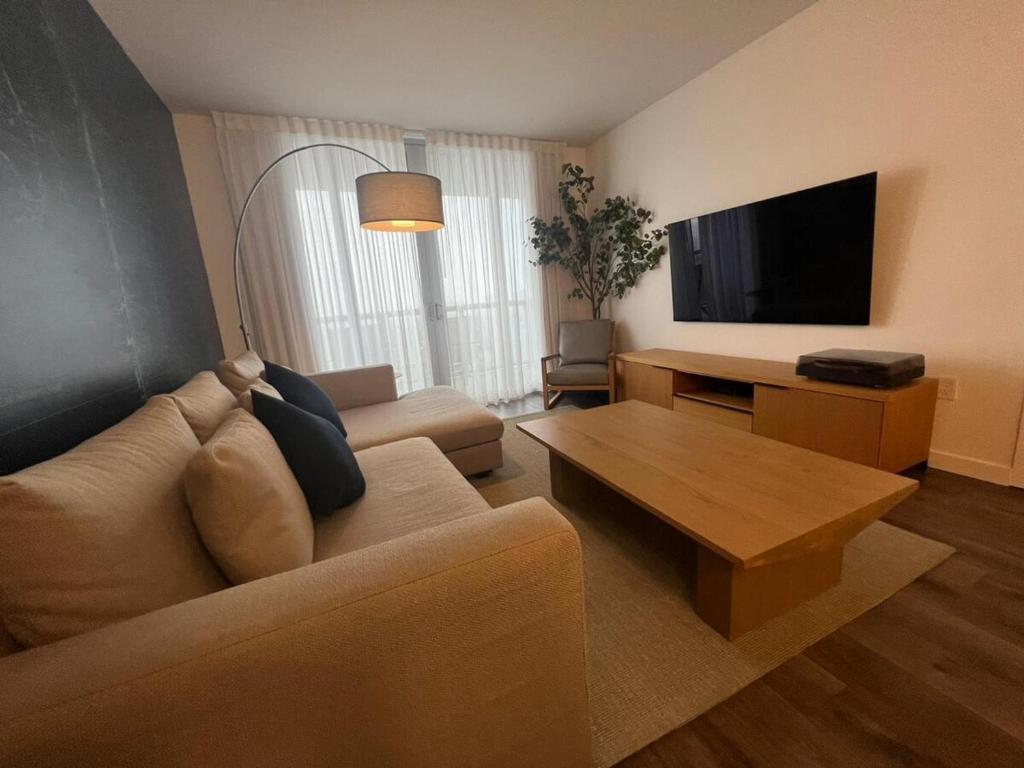 a living room with a couch and a flat screen tv at Miami Beach Cozy 1B withe Pool and Beach Service1507 in Hallandale Beach