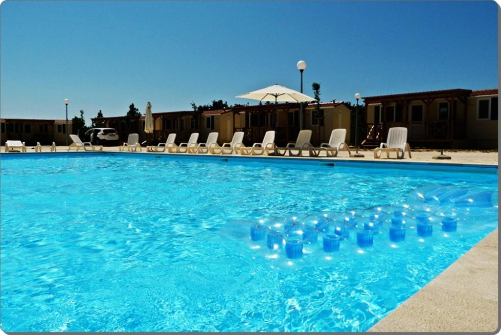 a swimming pool with blue glasses in the water at Mobile Homes Peroš in Zaton