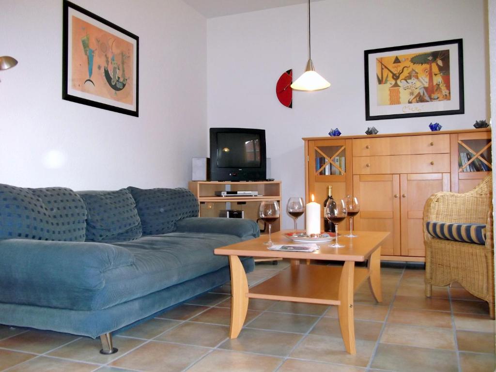 a living room with a blue couch and a table at Meeresbrise 06 in Neuhaus
