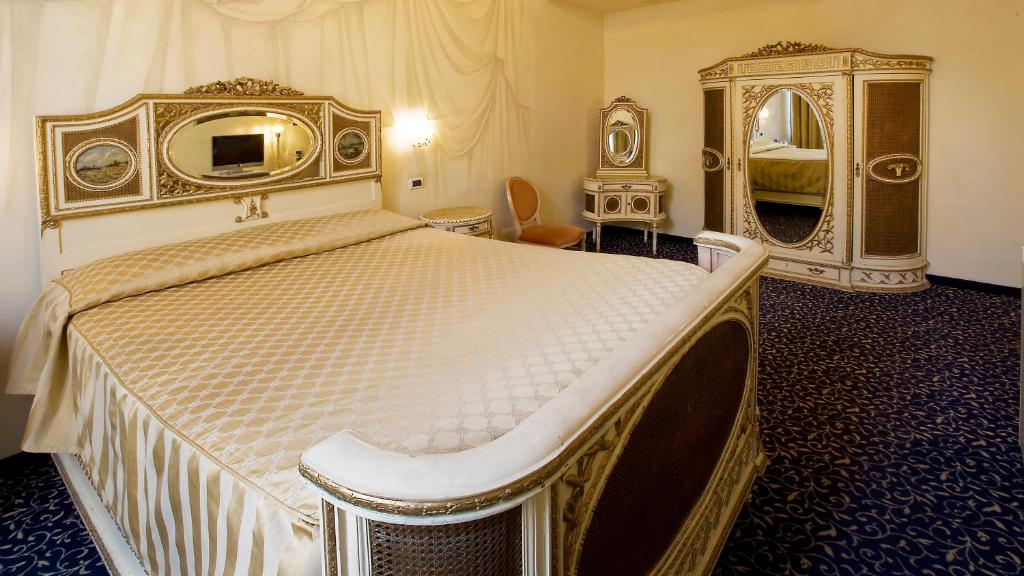 a bedroom with a large bed and a mirror at Hotel Principe in Venice