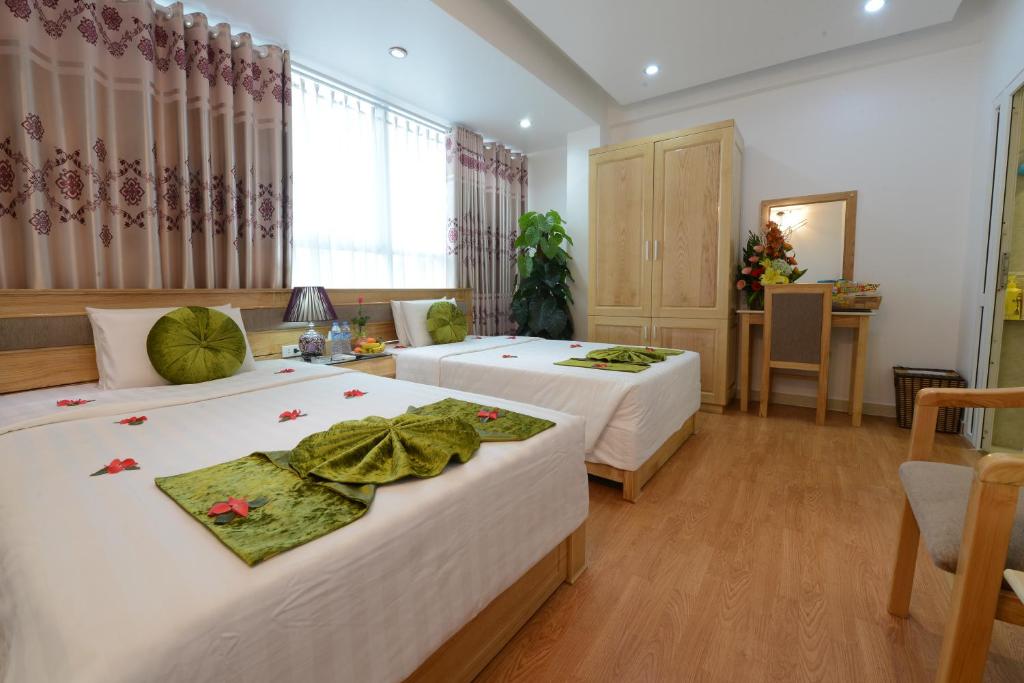 Un pat sau paturi într-o cameră la Blue Hanoi Inn Center Hotel