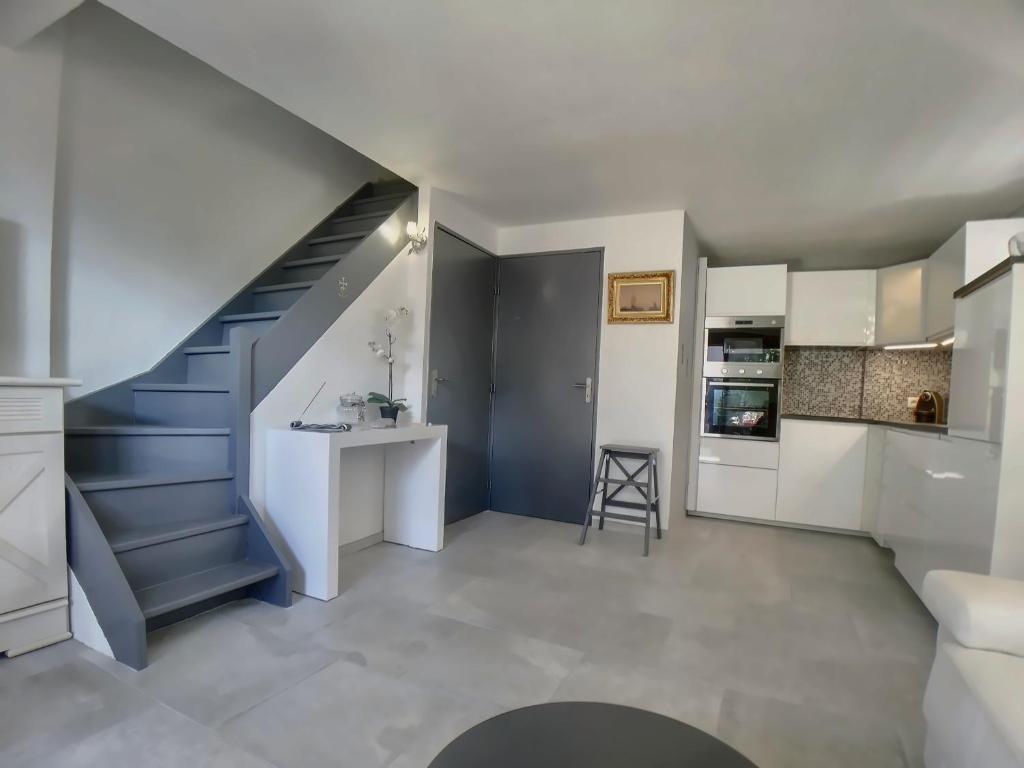 une cuisine avec un escalier et une table dans une pièce dans l'établissement Appartement 8 pers. avec terrasse, proche centre - FR-1-475-157, à Saintes-Maries-de-la-Mer