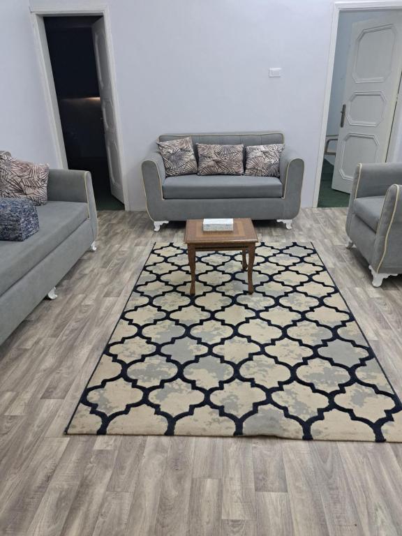 a living room with two couches and a rug at شقة مفروشة in Al Baha