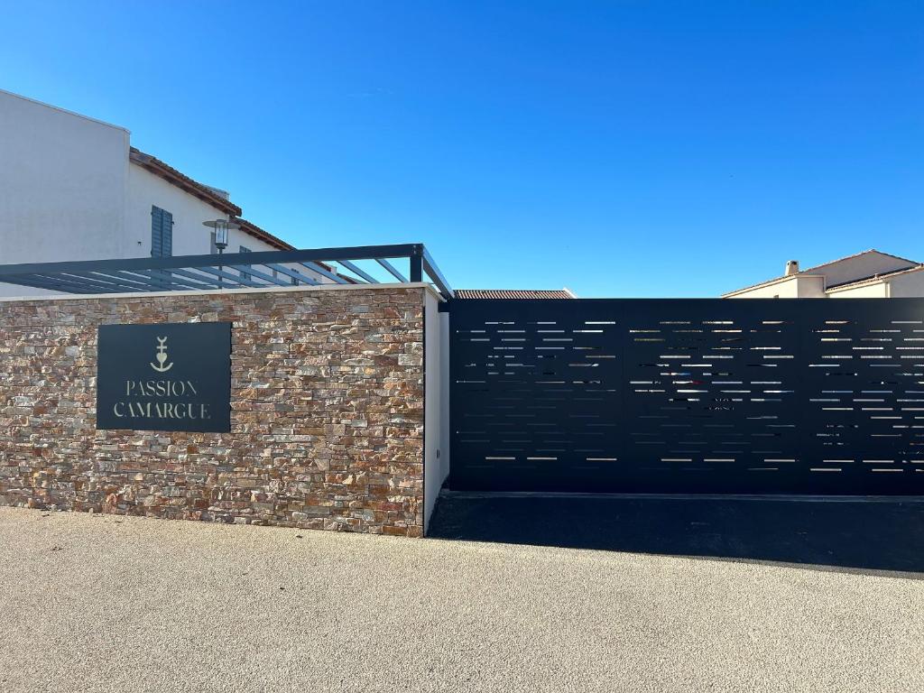 d'un bâtiment avec un portail et un panneau. dans l'établissement Maison neuve climatisée pour 4 pers. aux Saintes-Maries-de-la-Mer - FR-1-475-167, à Saintes-Maries-de-la-Mer