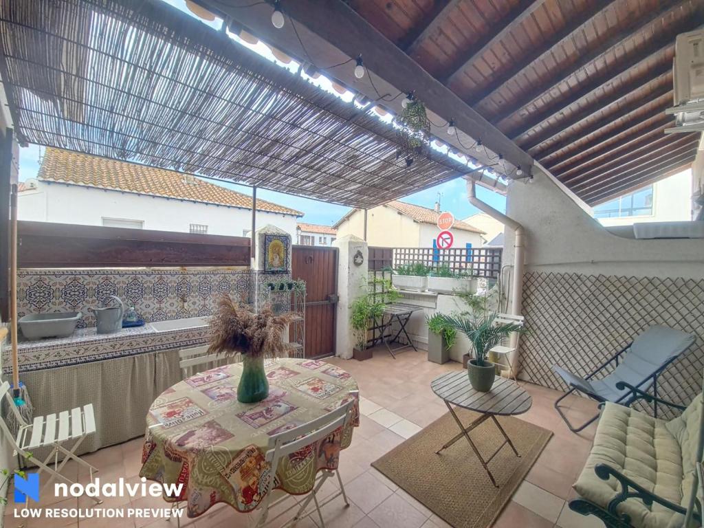un patio avec une table et des chaises sur un patio dans l'établissement Appartement 3 pers, climatisation, animaux admis - FR-1-475-170, à Saintes-Maries-de-la-Mer