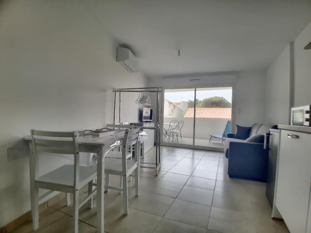 a kitchen and living room with a table and chairs at Studio 4 pers climatisé avec parking, à 100m de la mer - FR-1-475-174 in Saintes-Maries-de-la-Mer