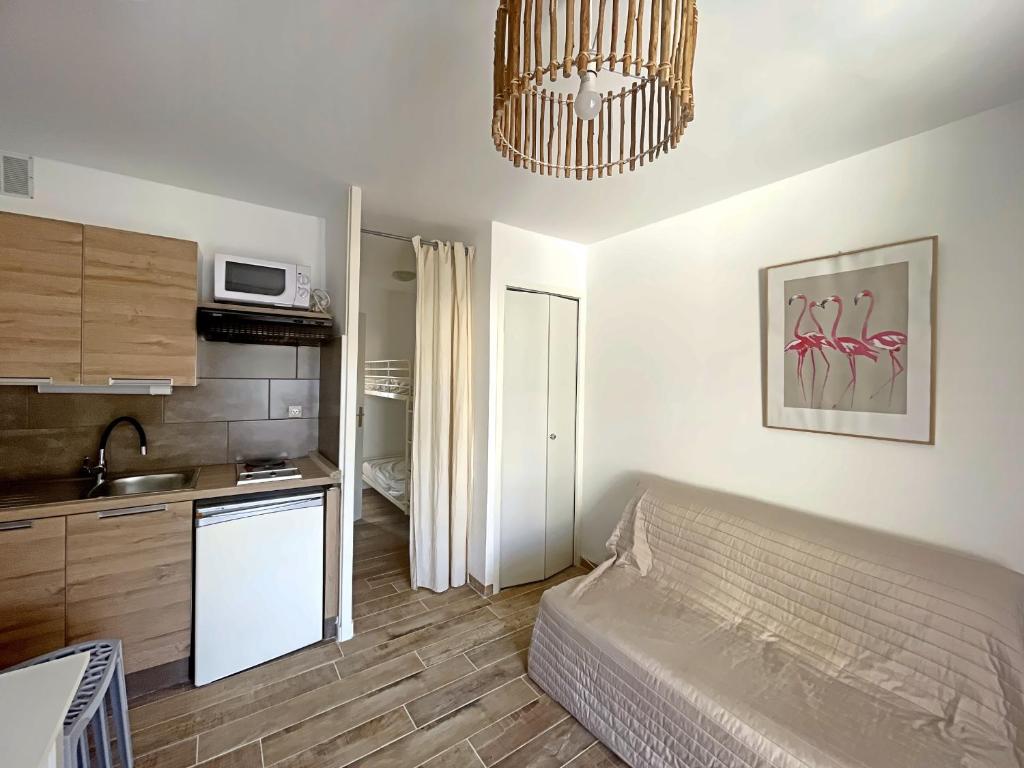 un salon avec un canapé et une cuisine dans l'établissement Appartement 4 pers avec cour sud aux Saintes-Maries-de-la-Mer - FR-1-475-179, à Saintes-Maries-de-la-Mer