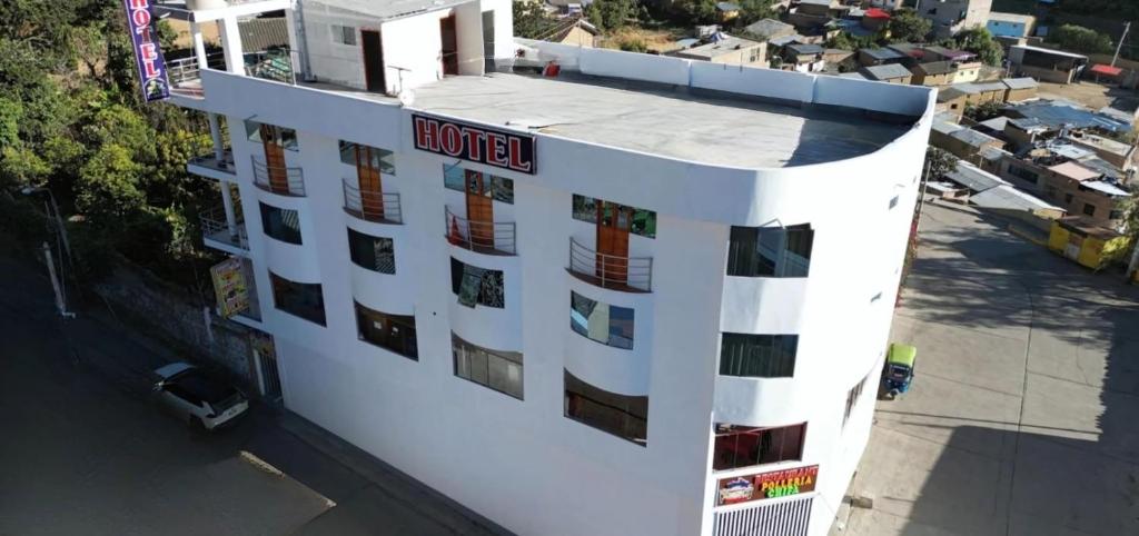 a white building with a sign on top of it at Hotel San Miguel in San Miguel