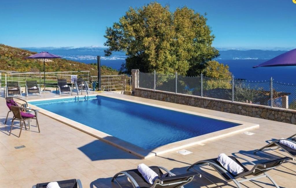 a swimming pool with lounge chairs and an infinity at Gorgeous sea-view VillaSol with pool & BBQ in Zagorje