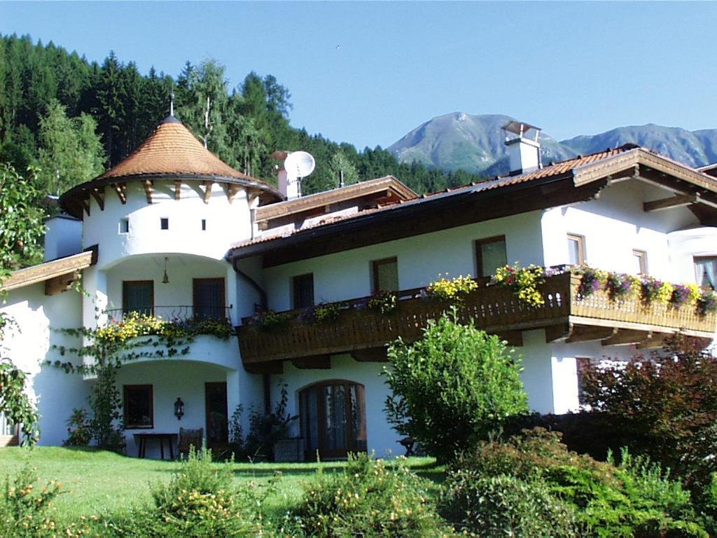 ein großes weißes Haus mit einem Turm darüber in der Unterkunft Landhaus Laner in Fulpmes