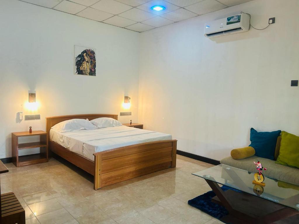 a bedroom with a bed and a couch at Villa Vinstar in Katukurunda-Kalutara