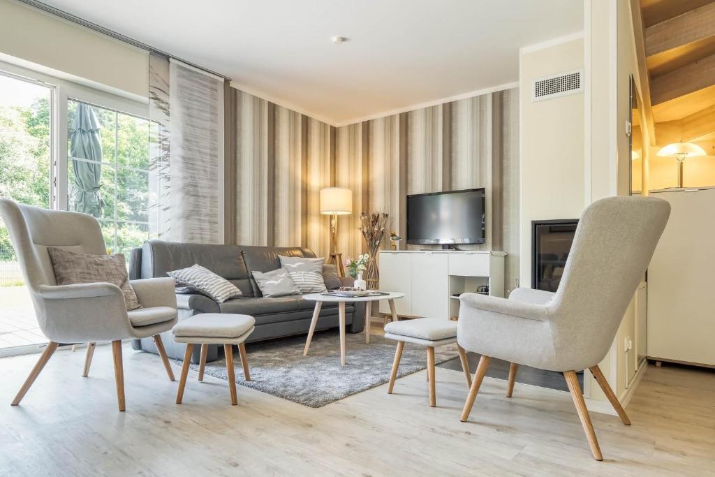 ツィングストにあるHuus Jetteのソファと椅子とテレビのあるリビングルーム