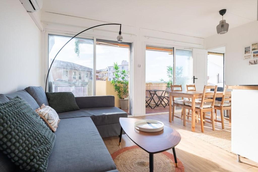 un salon avec un canapé et une table dans l'établissement FLC -Catalan Beach-Sea View- Clim - Terrace - Parking, à Marseille