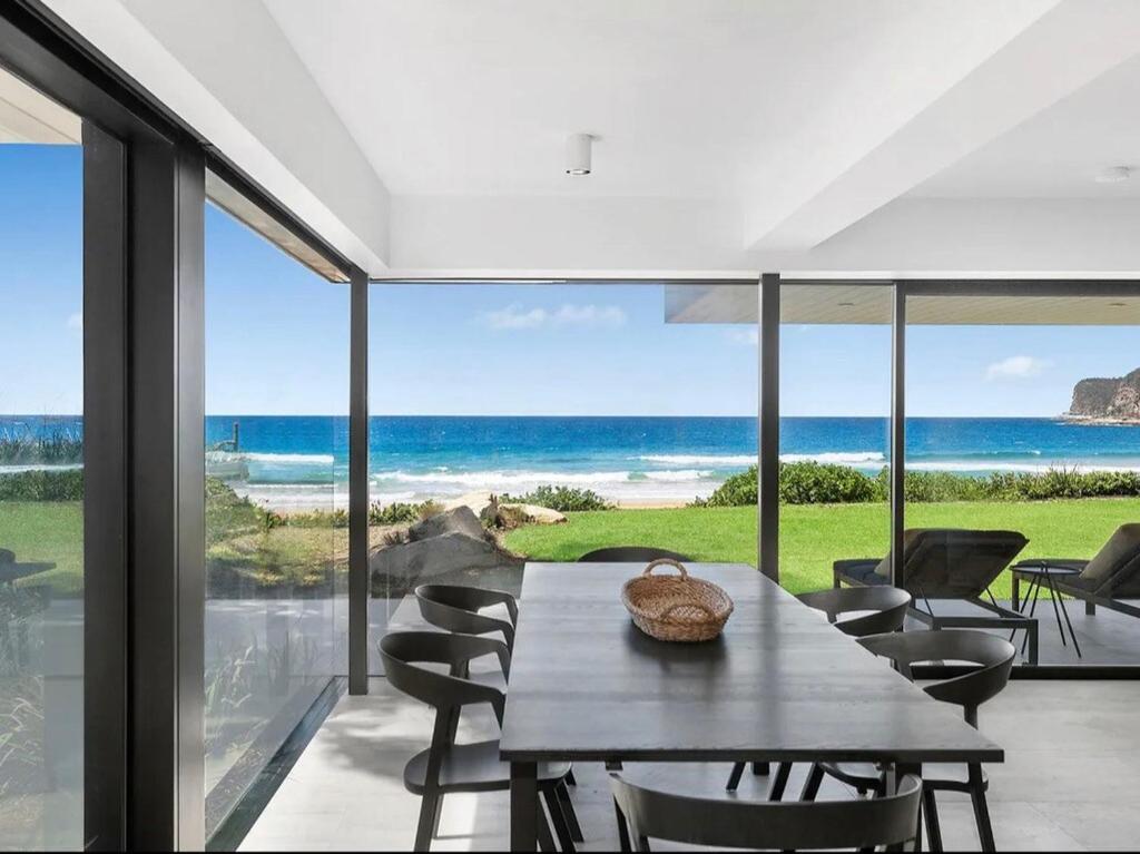 Un comedor con mesa y vista al mar. en Sea Belle North Avoca, en North Avoca