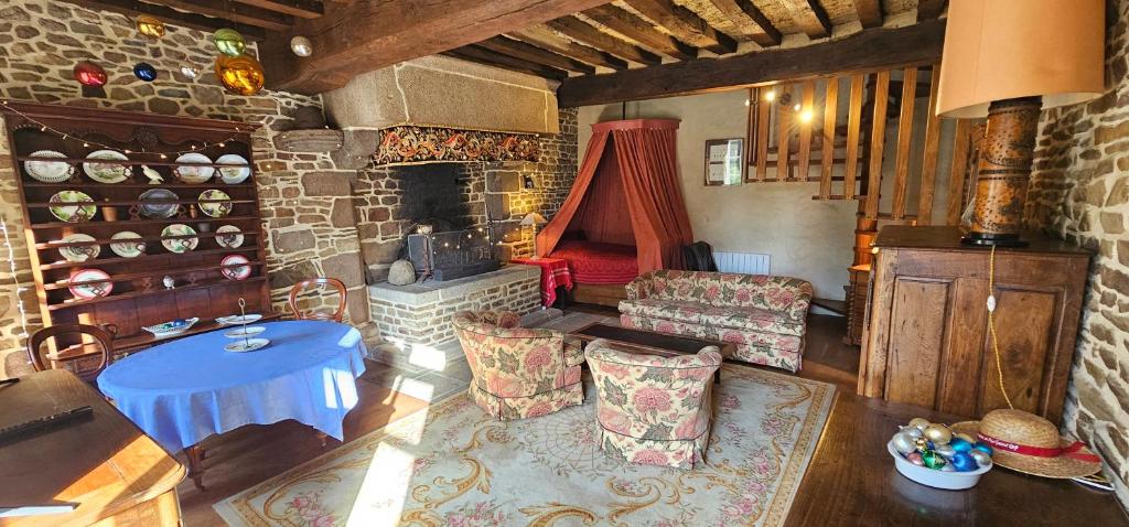 - un salon avec une cheminée en pierre et un canapé dans l'établissement Maison NORMANDE AUTHENTIQUE ERNESTINE, à Isigny-le-Buat