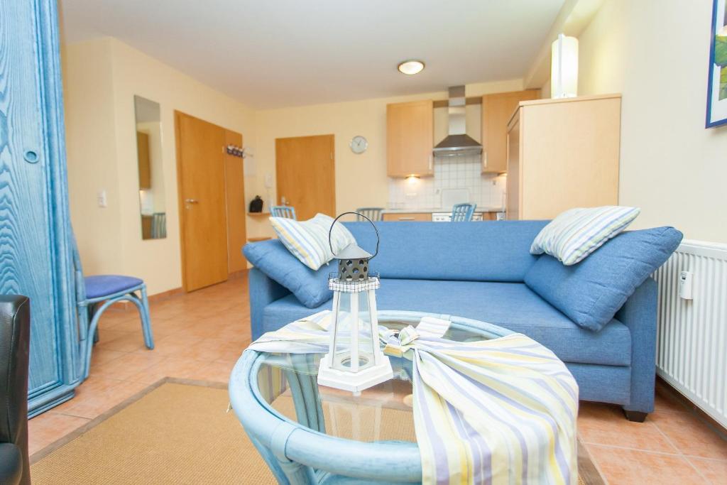 ein Wohnzimmer mit einem blauen Sofa und einem Glastisch in der Unterkunft Birkenstraße 7 Whg 2 in Zingst