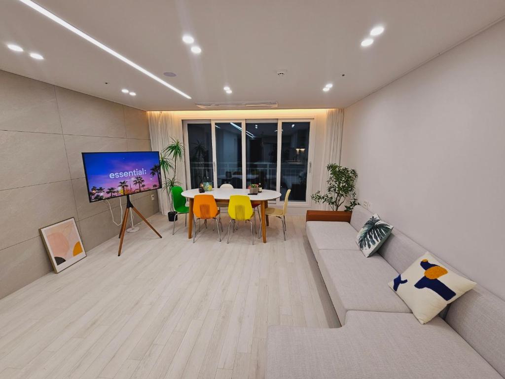 富川市New 패밀리 & 친구 여행 모임 청결하고 쾌적한 넓은 신축아파트 주차 편리 쓰리룸的带沙发、电视和桌子的客厅