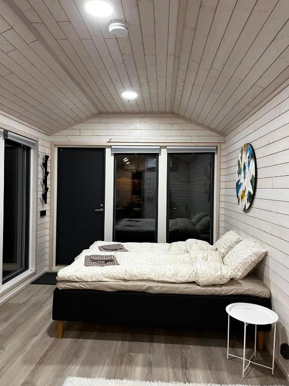 a bedroom with a bed in a room with windows at Willa Rauha 1A, minikoti katetulla terassilla, ei saunaa in Lumijoki
