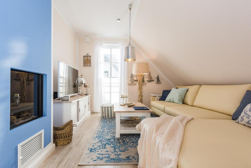 a living room with a couch and a tv at Lütten Kate 03 in Zingst
