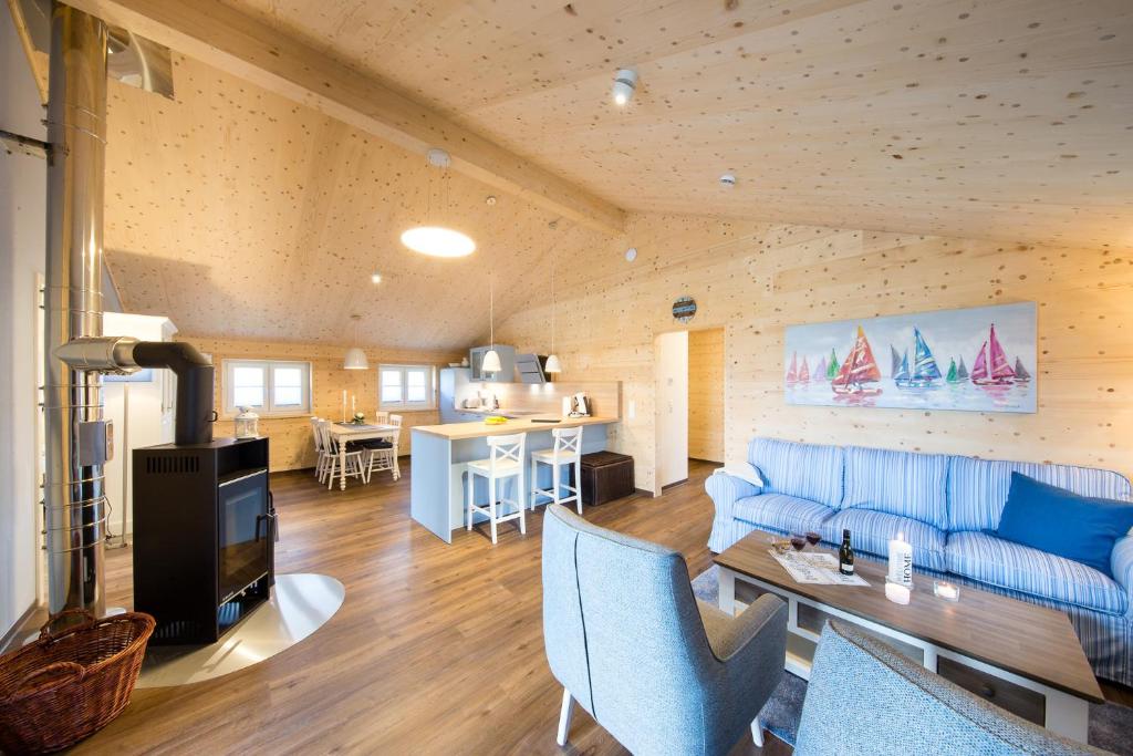 a living room with a blue couch and a table at Typ A plus "Schoner" -Skipperhaus- in Pelzerhaken