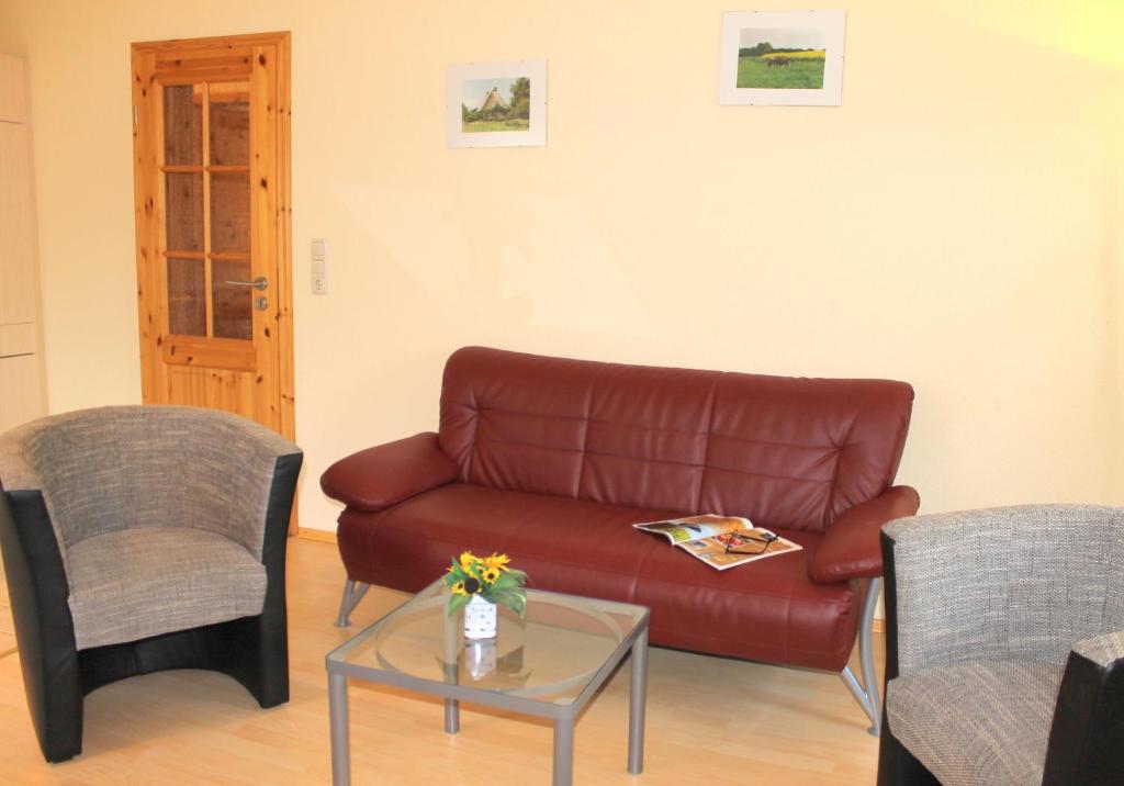 a living room with a leather couch and two chairs at "Hof Triangel - Whg 1" - Bauernhofurlaub in Riepsdorf