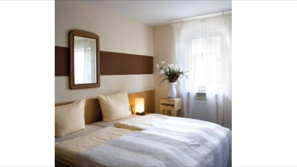 a bedroom with a large white bed with a mirror at Hotel Krone in Ostfildern