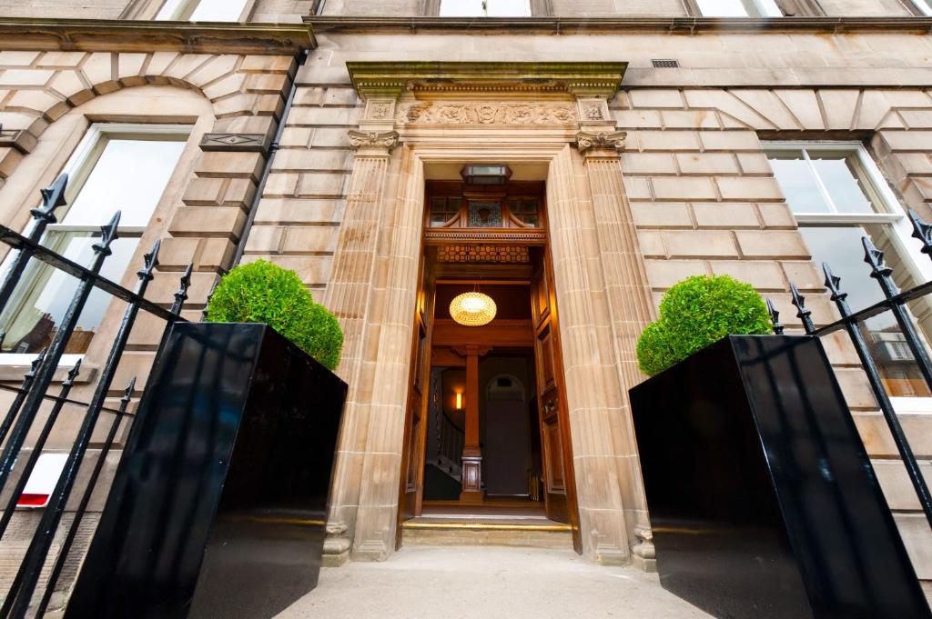 una entrada a un edificio con puerta de madera en The Place Hotel, en Edimburgo