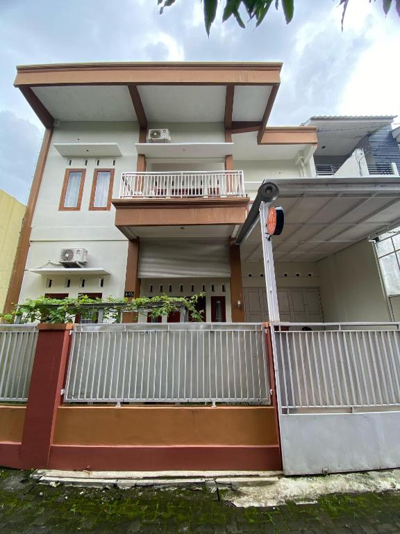 a house with a white fence in front of it at Ata Homestay Purwokerto in Purwokerto