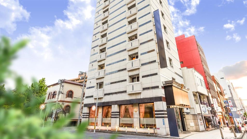 山形市Hotel Yamagata Hills Ekimae Odori的街边的一栋高大的白色建筑