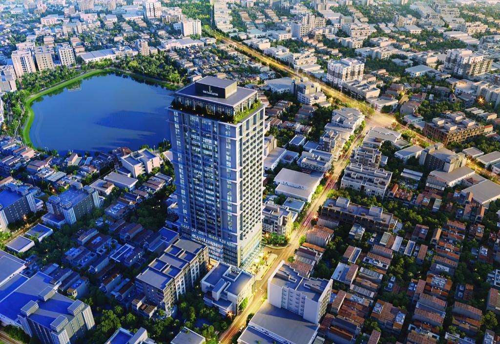 an aerial view of a tall building with a lake at Lancaster Hanoi City Center Apartments in Hanoi