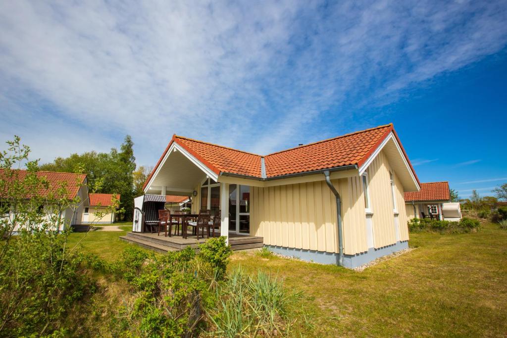 a small house with an orange roof on a yard at Typ H "Lord Nelson" -Sundhaus- in Pelzerhaken