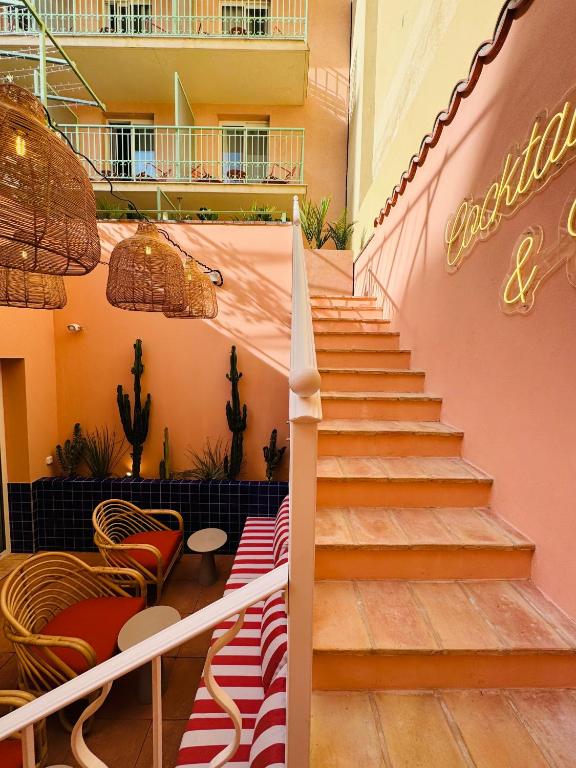 a staircase in a building with red and white chairs at Hôtel Gabriel in Menton