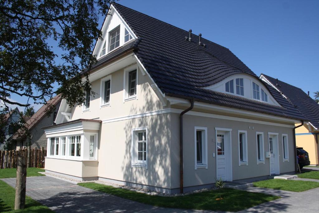 a white house with a black roof at FeHa Strandmügge in Zingst