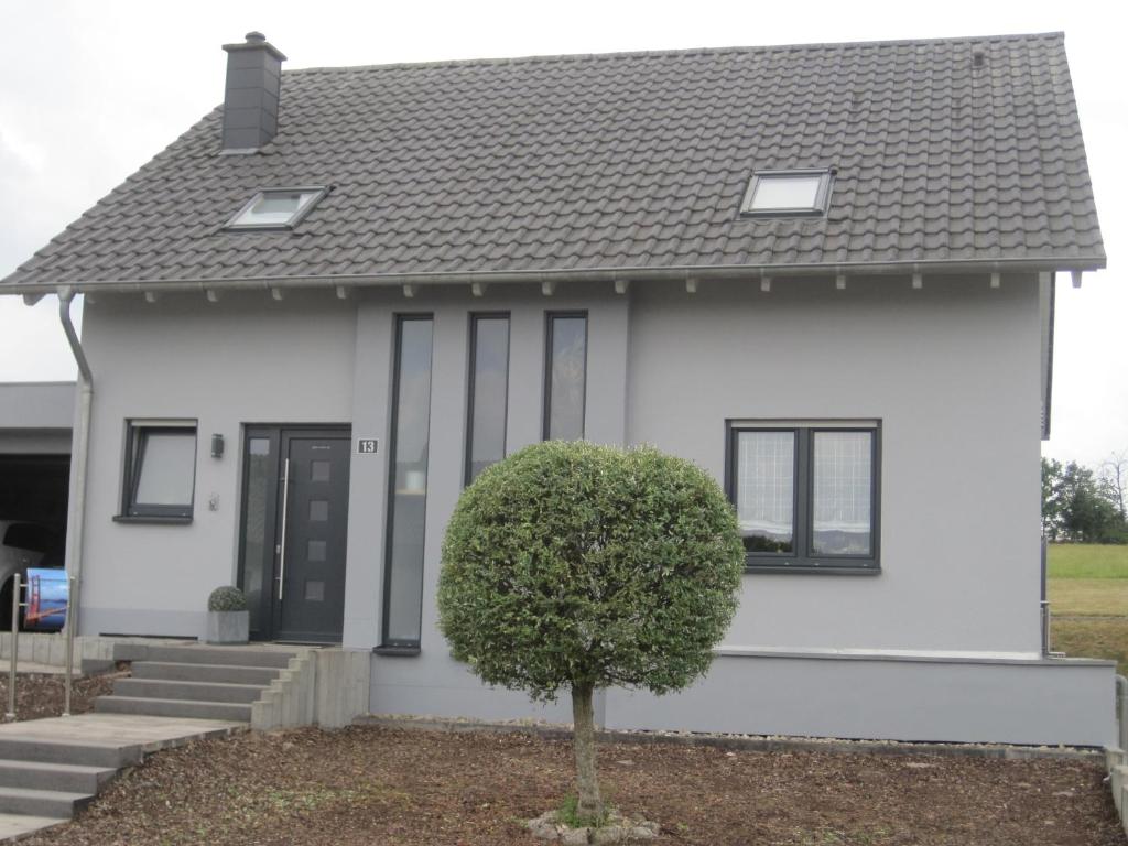 a white house with a black roof at Ferienwohnung-Haus-Perkow in Illingen