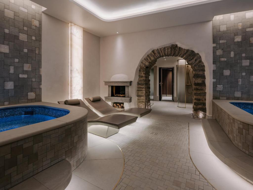 a large bathroom with two soaking tubs and a fireplace at The Burman Hotel - Member of Small Luxury Hotels of the World in Tallinn