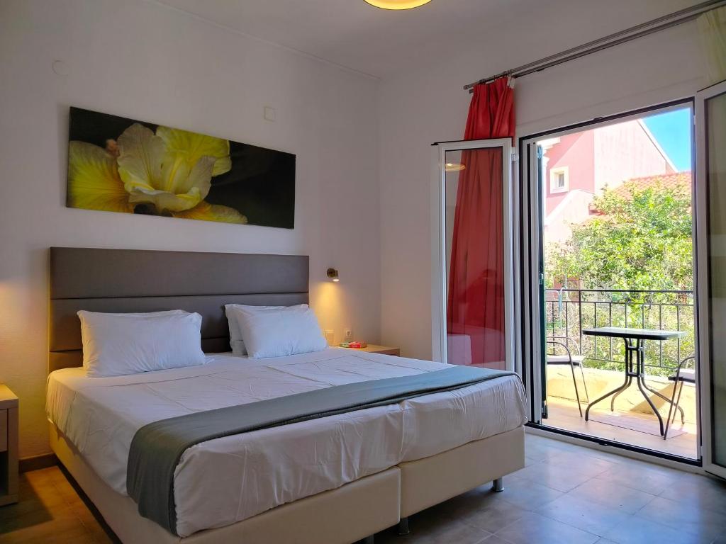 una camera da letto con un letto e una porta scorrevole in vetro di Oliveland Apartments a Kávos