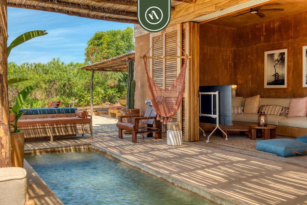 a living room with a swimming pool in a house at Stunning Two-bedroom Ocean View House - Mazul in Tlachicón