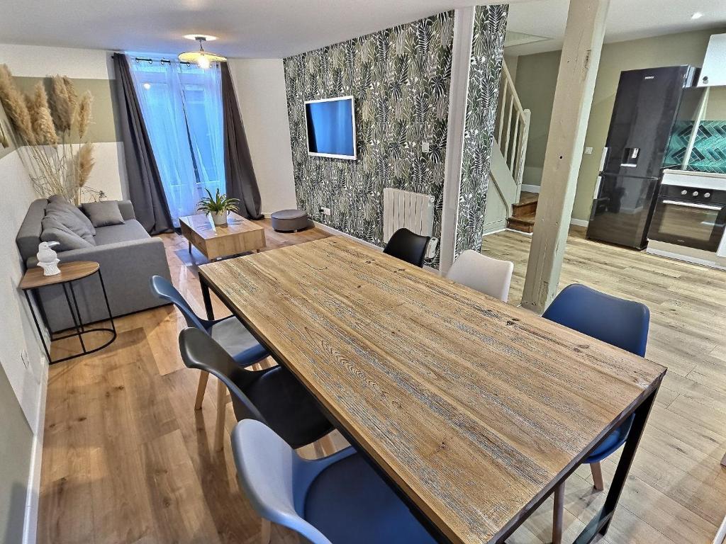 a living room with a wooden table and chairs at Maisonette Cozy, Neuf, Centre-ville, Wifi in Elbeuf