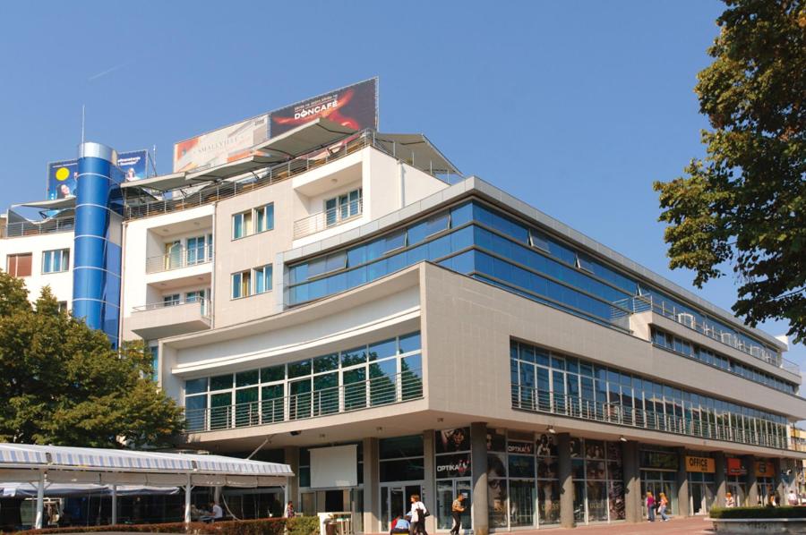 un grande edificio con persone che camminano davanti di Hotel Turist a Kraljevo