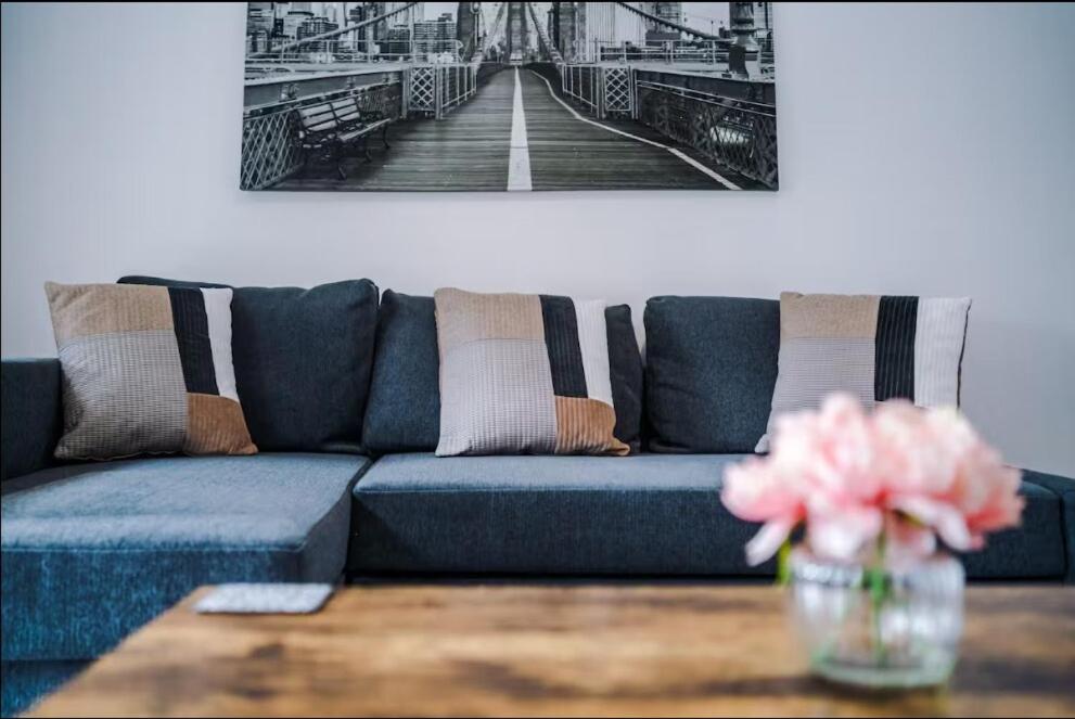 a blue couch in a living room with a table at Modern & Cozy 3BR House - Sleeps 8 in Golborne