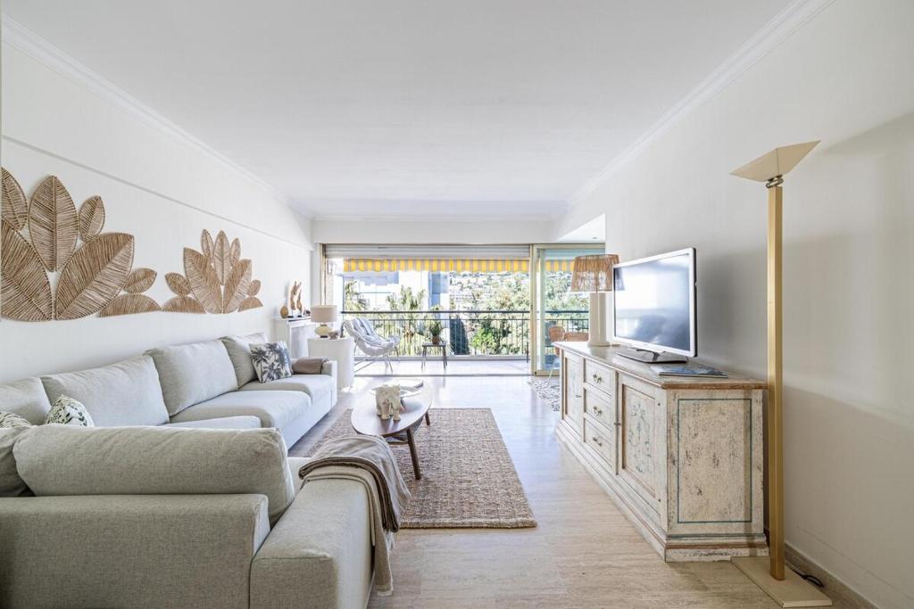 un salon avec un canapé et une télévision à écran plat dans l'établissement PALM BEACH, sea view apartment, 100m from beaches, à Cannes