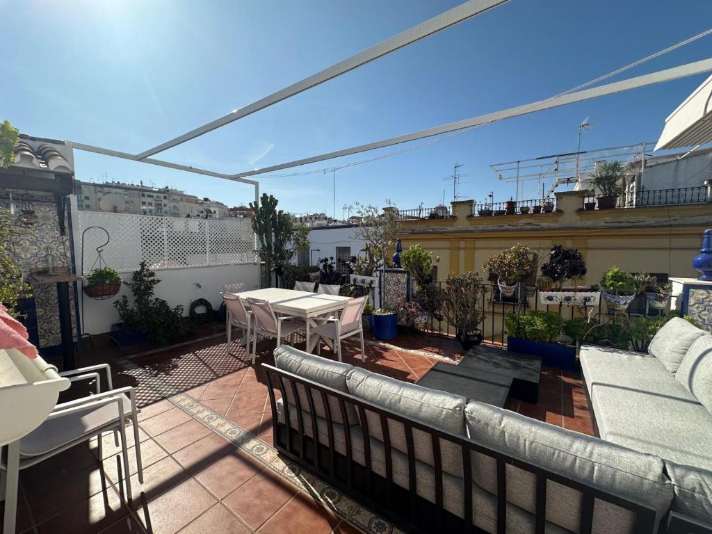 a patio with a table and chairs on a balcony at La Alcazaba de Triana in Seville