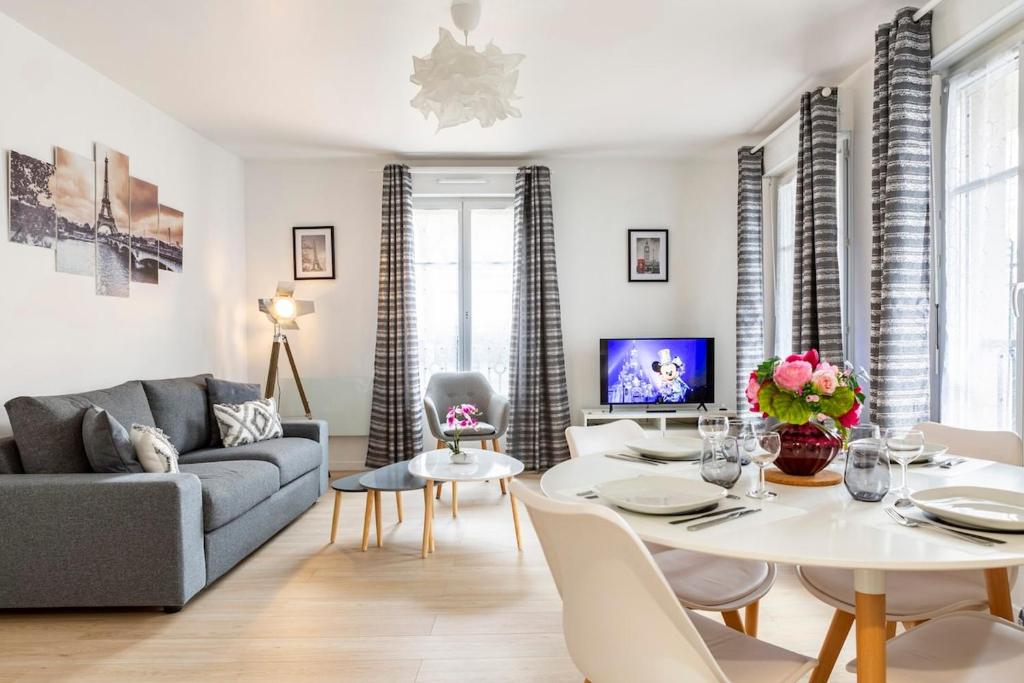 a living room with a couch and a table and chairs at Casaminnie - Appartement à 8 min de Disneyland Paris in Bussy-Saint-Georges