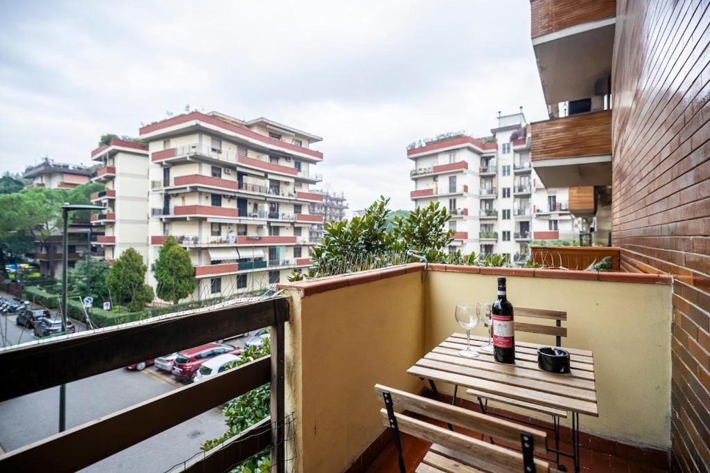Una botella de vino sentada en una mesa en un balcón en Near Airport 8 Guests - Big Elegant Apartment, en Florencia