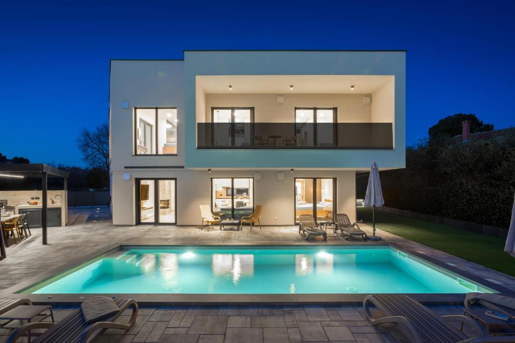 a villa with a swimming pool at night at Villa Mila - NEW 2025 in Medulin