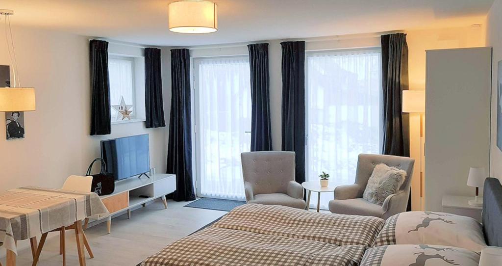 a living room with a bed and a tv and a couch at VILLA BERGAUF, Studio Apartment König Ludwig II Kini INKL KÖNIGSCARD !! in Hohenpeißenberg