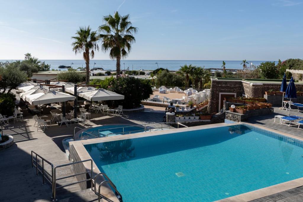 una piscina en un resort con el océano al fondo en Hotel Punta Imperatore, en Isquia