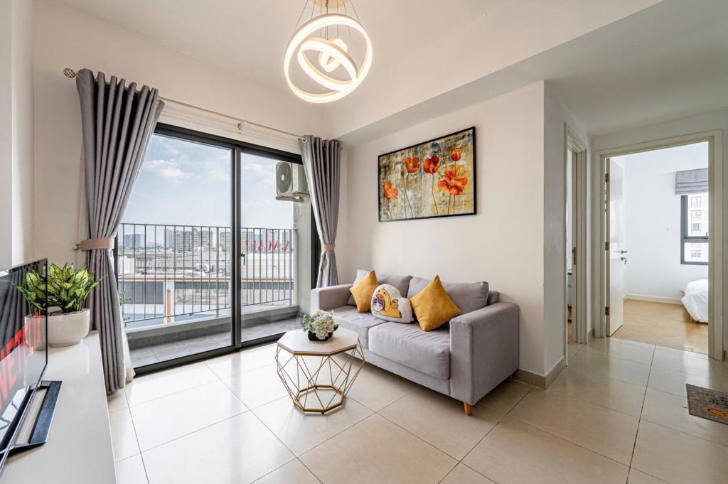 a living room with a couch and a large window at Solena Landmark Riverside Apartment in Mậu Lâm (3)