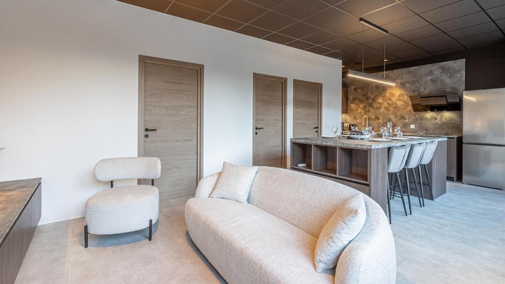 a living room with a couch and a kitchen at Le Dauphiné 2 - Allevard in Allevard