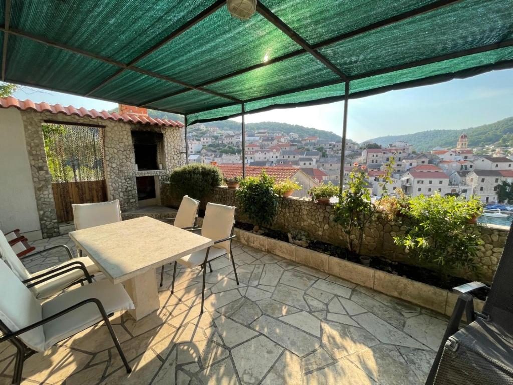 a table and chairs on a patio with a view at House Zarko in Pučišća